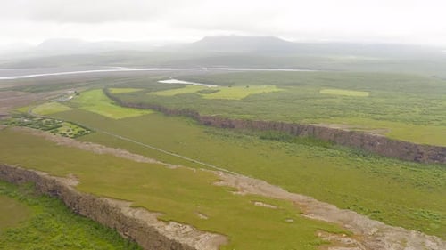 Flying Over Thin Clouds Moving Over Famous Asbyrgi Canyon In Iceland. - aerial