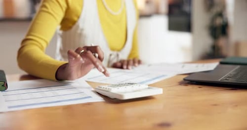 Adult Calculates Finances at Desk in Home Office