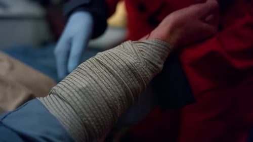 Medical professional bandages arm of patient in hospital