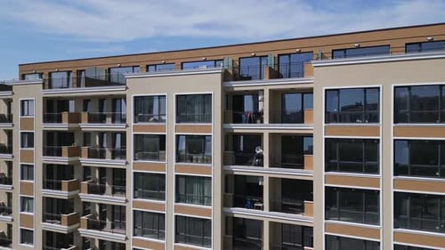 Aerial Footage of a Modern Residential Building with Glass Balconies Clean Lines and Large Windows