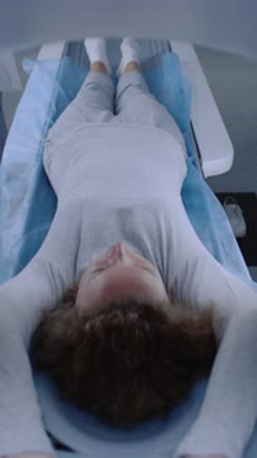 Female Patient on CT PET or MRI Bed Navigates Inside Machine