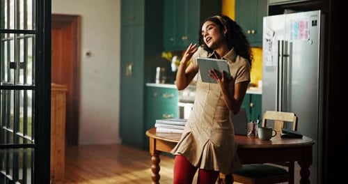 Woman Talking on Phone and Holding Tablet Indoors