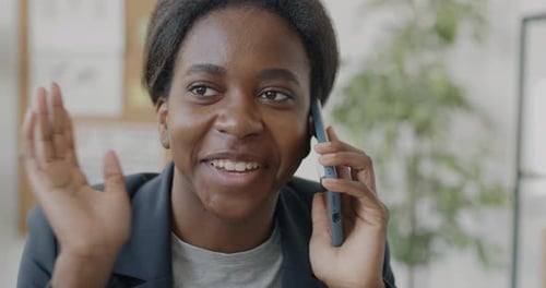 Closeup of Female Entrepreneur Speaking on Cellphone and Smiling Working in Office Alone