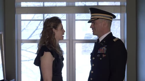 Woman and military man face each other indoors
