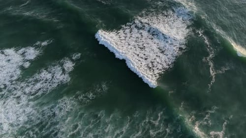 Aerial view of a powerful ocean wave cresting in the deep sea