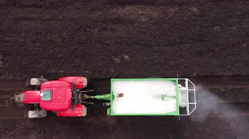 Tractor Spreads Dry Mineral Fertilizers on a Field