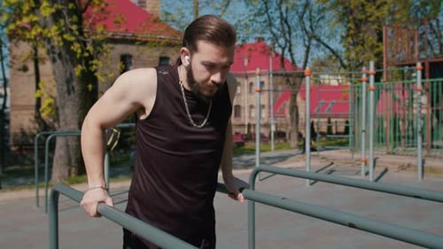 Athletic Lebanese Man in Sportswear Practicing Dips on Parallel Bars Training Triceps on Playground