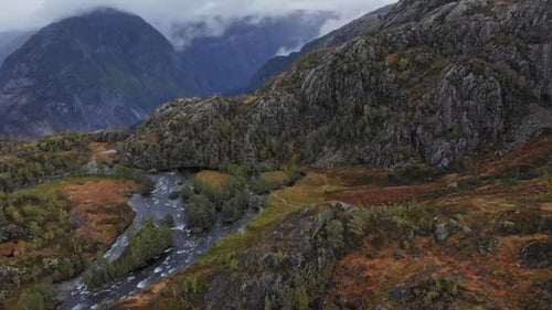 Dramatic aerial flying over river in the high mountains of Norway