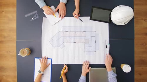 Architekten diskutieren gemeinsam am Bürotisch über das Bauplanprojekt