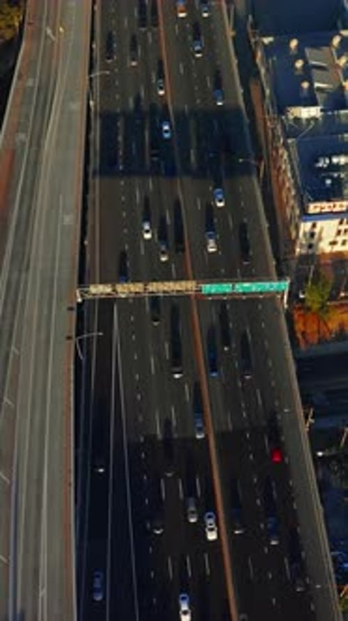 Flight above the overhead road with lots of cars moving by. Los Angeles roofs with helicopters on