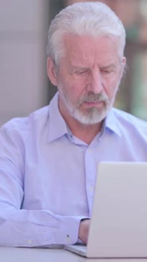 Senior Man Working on Laptop Gesturing No
