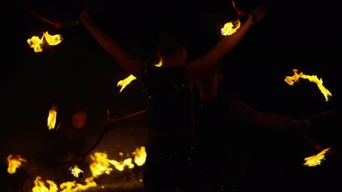 Fire Dancers Twirling Flames at Night