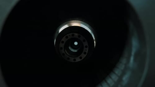 Gros plan industriel à travers un boîtier cylindrique sur un assemblage de rotor usiné pendant qu'un technicien aligne