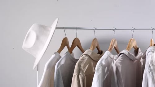 Neutral Color Clothing Hanging on Rack Panning Shot