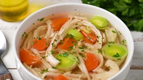 Homemade chicken soup in white bowl