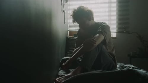 Frustrated Man Hitting Head against Wall and Punching It with Fist