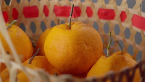 Hand picking a ripe orange from a basket, vibrant color detail, close-up