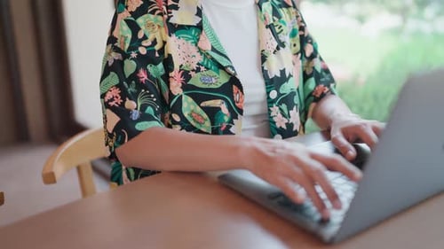 Person Typing on a Laptop at Home