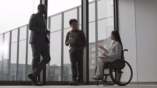 Business Professionals Talking By Window in Office