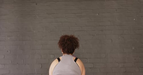 Medicine ball tossing upward and striking brick wall before rebounding into catch, in training