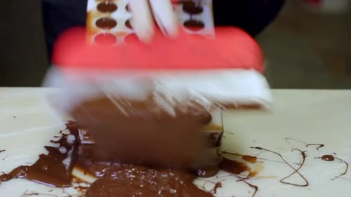 Chocolate Maker Spreads Chocolate Over Candy Mold