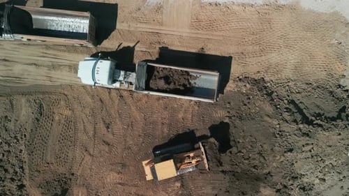 Aerial View of Construction Site with Trucks