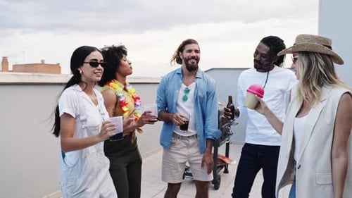 Amigos curtindo uma festa no terraço, dançando e bebendo