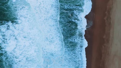 TopDown Aerial View of Waves Crashing on a Sandy Shore