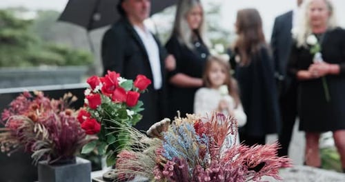 Flowers, family and funeral by tomb at cemetery, graveyard or outdoor for farewell or burial