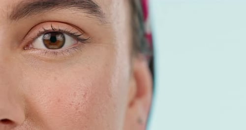 Closeup, eye and woman with vision, wellness and optometry on a blue studio background