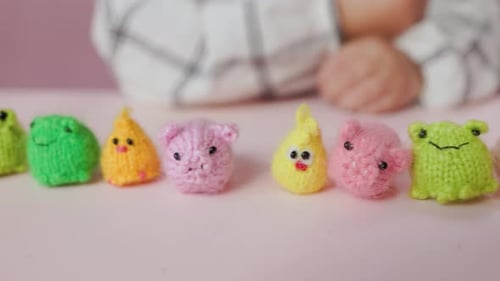 Mädchen spielt mit kleinen gestrickten Tierspielzeugen in einem Zimmer zu Hause