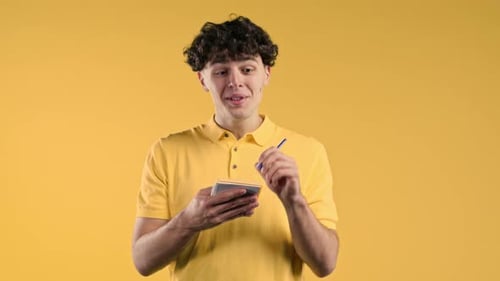 Man Writing Notes in Planner Curly Haired Guy with Pen