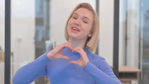 Young Woman Makes Heart Shape With Hands