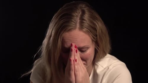 Distressed Woman Crying with Hands Clasped