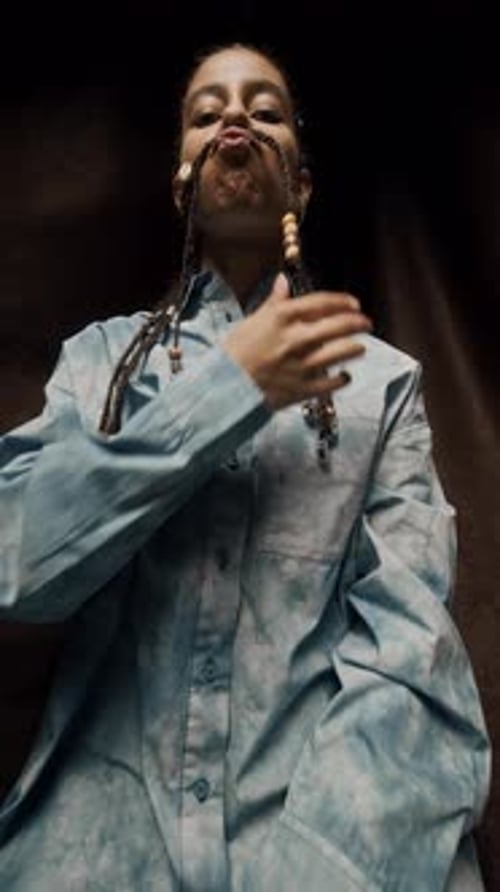 Woman Posing with Braids Between Lip and Nose
