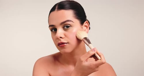 Blush, makeup brush and beauty with face of woman in studio for cosmetic, glow and aesthetic