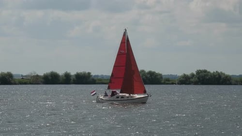 Sailing boat with red sails on lake Eemmeer in the Netherlands