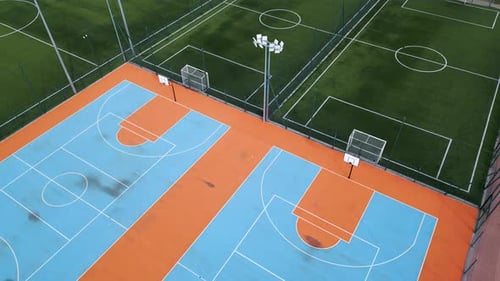 Aerial View of Outdoor Basketball and Soccer Courts with Vibrant Blue Orange and Green Colors The