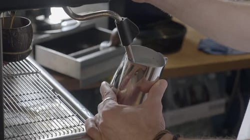 Barista Steaming Milk for Latte at Cafe