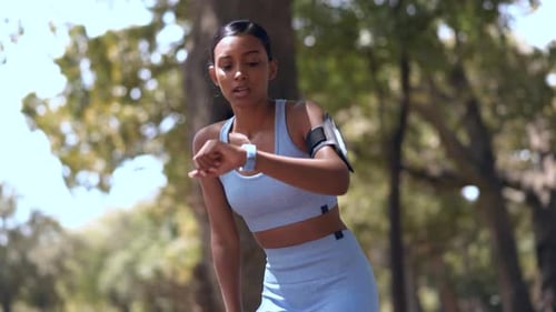Woman Looking at Smart Watch in Park