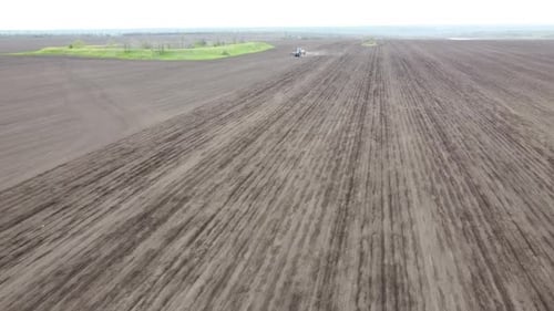 Blue tractor OA working on the field in Ukraine