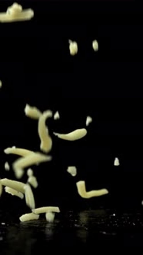 Shredded Cheese Falling on Black Background Filmed on a Highspeed Camera at 1000 Fps