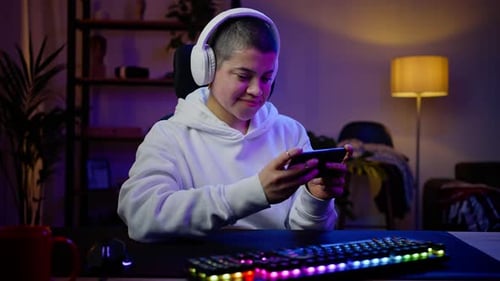 Woman in Hoodie Rests Playing Video Game on Mobile Phone