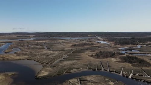 Gently descending drone slowly approaches a tidal marsh on the edge of the Atlantic. Aerial. Salt ma