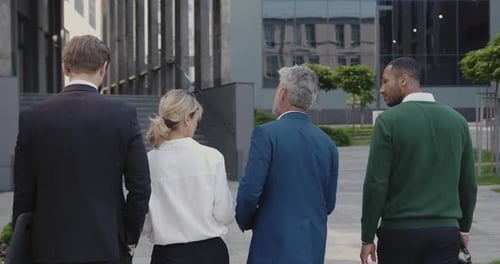Back View of Business People Going From Work and Discussing Project