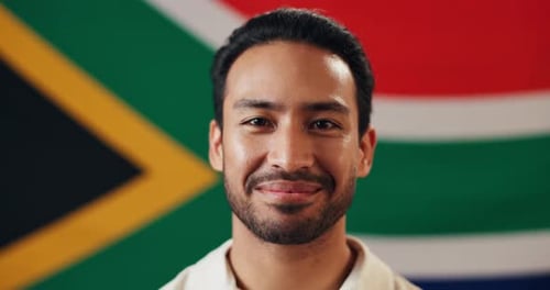 Smiling Man Standing in Front of Country Flag