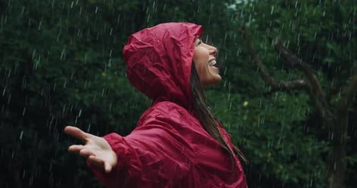 Woman Joyfully Playing in Rainfall