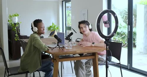Divers co-animateurs accueillent les spectateurs pour enregistrer, tester le son et parler au micro dans la salle à manger