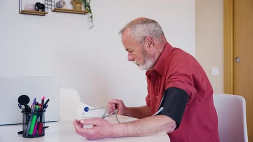 Senior Man Measures Blood Pressure at Home