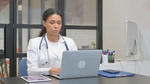 Female Doctor Works on Laptop in Modern Office